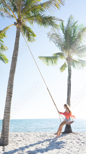 Vacation concept. Young woman swing on a beach swing. Happy traveller women on the Phu Quoc beach © Hryhorii