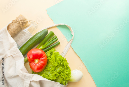 Fresh fruits and vegetables in eco bag on beige and turquoise color background with copyspace. Plastic free concept. photo