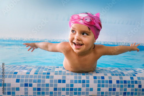 Happy child in the swimming pool. Before swimming lessons Beautiful girl smiling in the pool before swimming in the competition