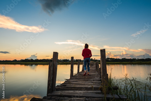 Woman walking on wooden bridge