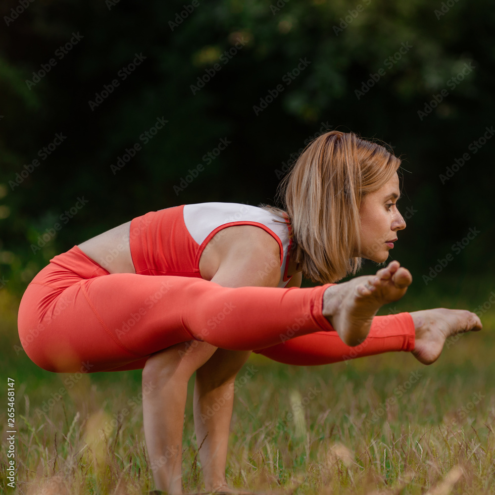 Yoga woman standing on her arms with straight legs in park Yoga woman standing on her arms with straight legs in park