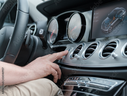 Man testing additional car control at luxury car