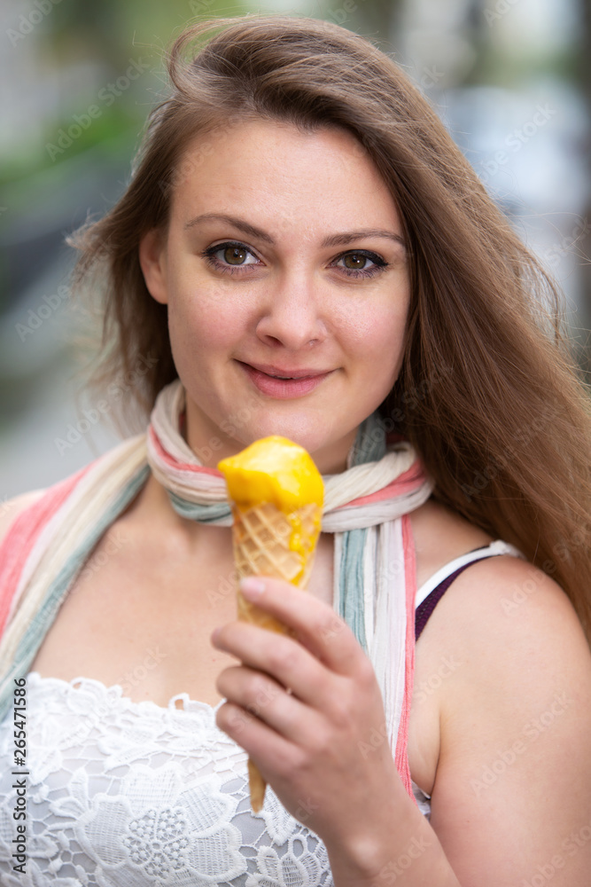 young brunette woman outdoors holding an ice cream cone young brunette woman outdoors holding an ice cream cone