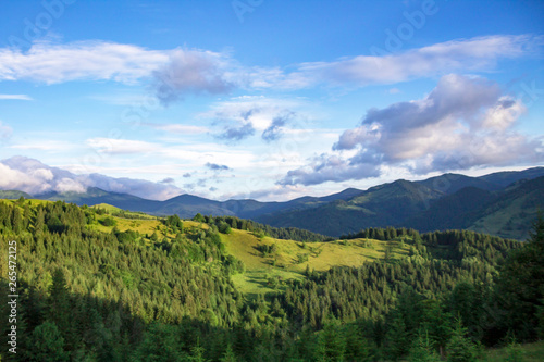 Scenic summer or spring mountain view with cloudy sky. Ukraine, Carpathians, Dzembronia High mountains in vivid color. Nobody. Beautiful mountain lanscape or valley.