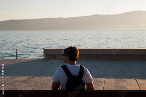 Man sitting on bench and looking at the sea