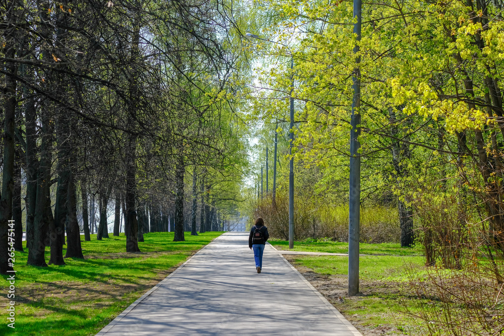 Lonely woman walking in the spring park