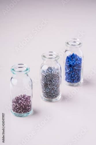 Varied colors beads in transparent bottles white background