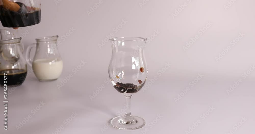 Putting coffee jelly and pouring sweet milk in glass cup Putting coffee jelly and pouring sweet milk in glass cup
