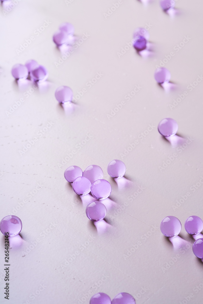 Purple scattered marbles on white background close up