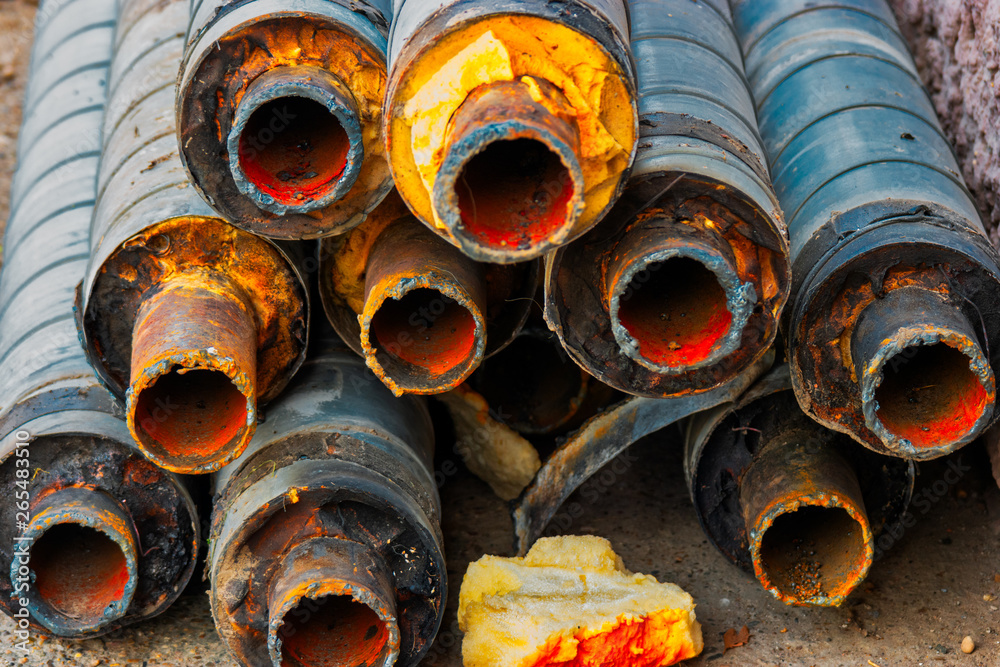 Many old rusty pipes with footprint of welding on side