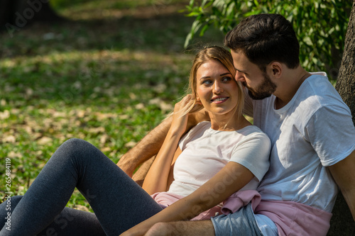 The lover sit together in public park Man holding with his girlfriend with happy smiling.