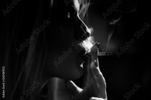 Woman smoking a cigarette, black and white,artistic, some photo grain