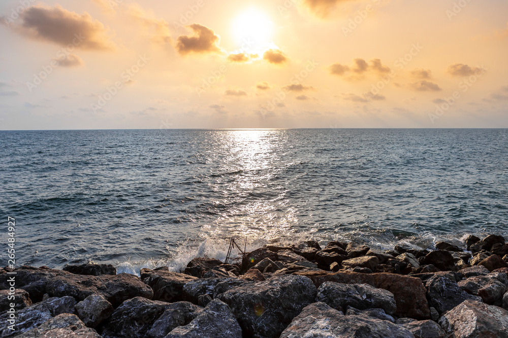 Beautiful sunset at the beach in Thailand, stone beach, summer and holiday concept