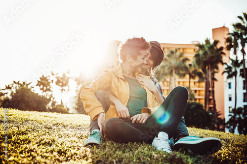 Happy gay couple embracing and laughing together in park outdoor - Young lesbian women having a tender moment at sunset outside  - People, Lgbt, bisexuality, relationship lifestyle concept © Alessandro Biascioli