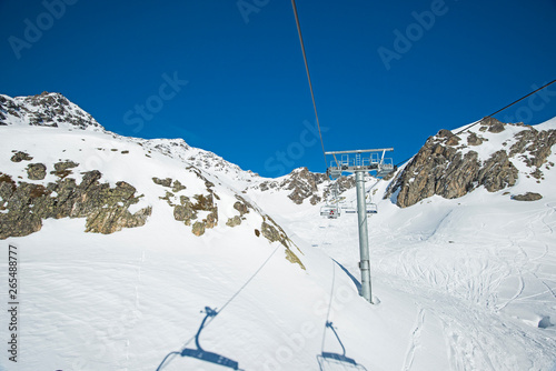 Traveling up an alpine mountainside on ski chair lift © Paul Vinten