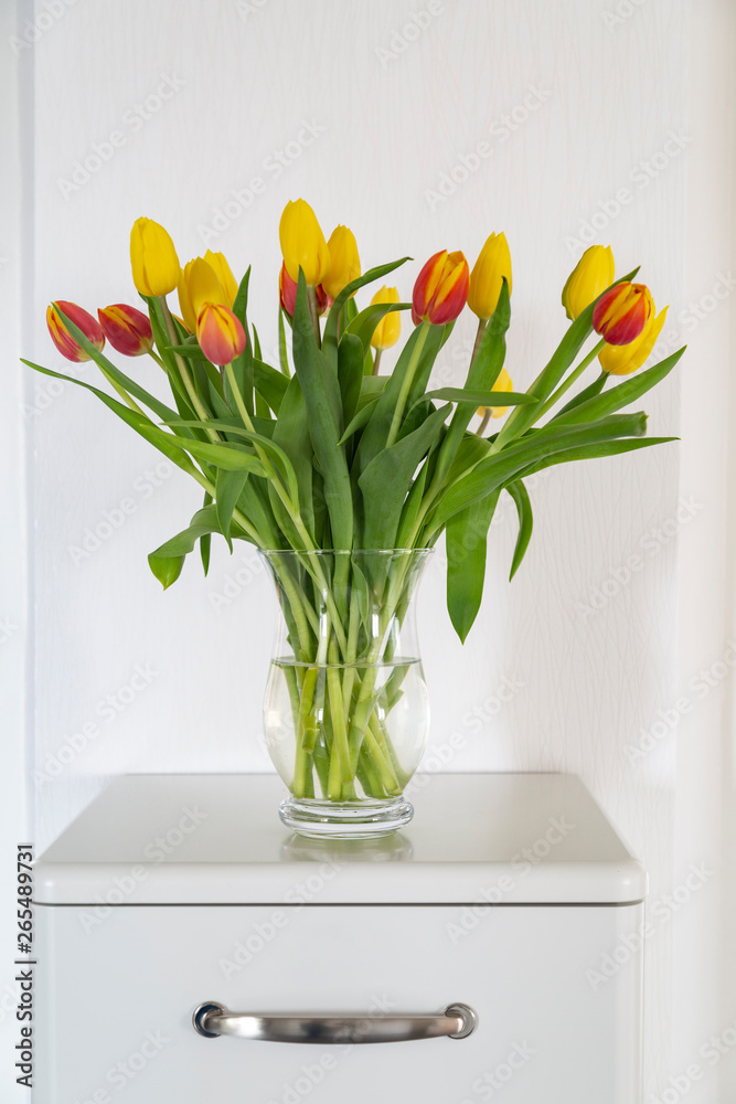 Bouquet of red and yellow tulips on a white sideboard Bouquet of red and yellow tulips on a white sideboard