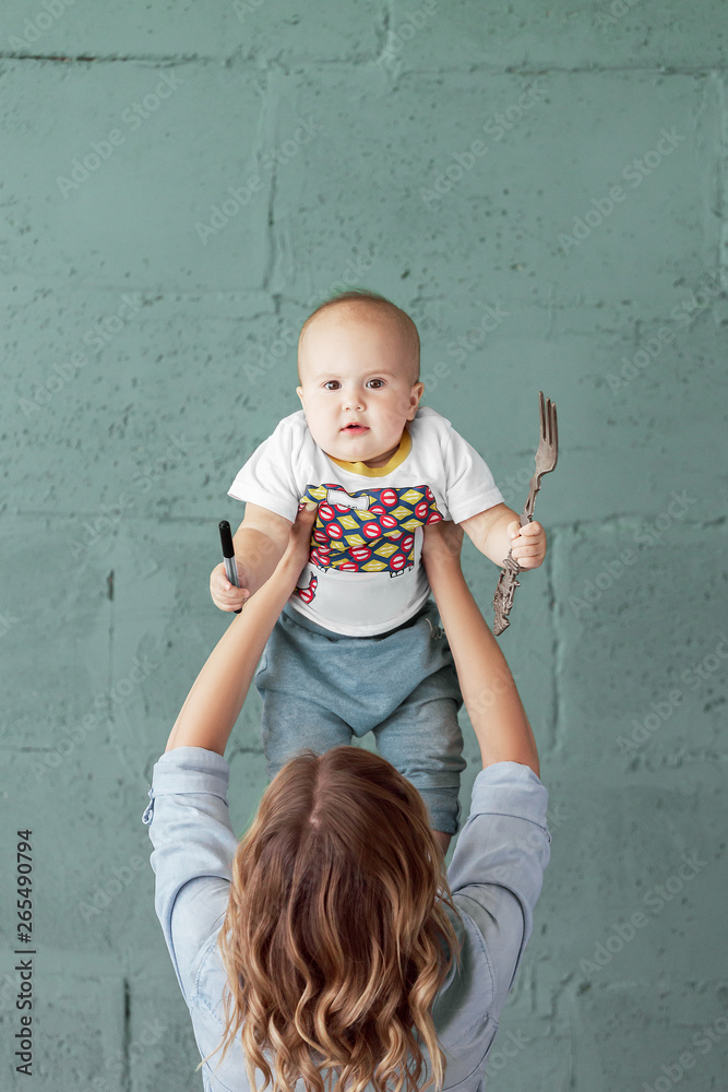 Fototapeta premium Young mother holds her confused little baby