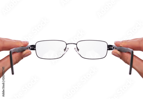 Slika na platnu Glasses in a female hand on white background.