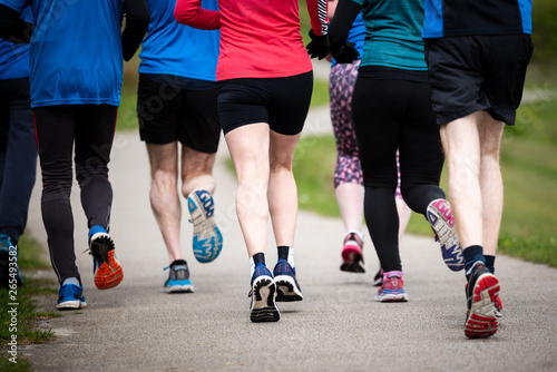 Group of people of mixed ages running together outside, preparing for the marathon