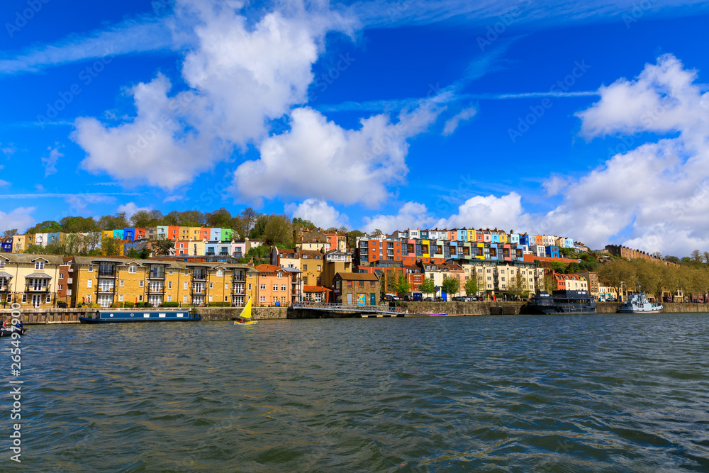 View across the river Avon of fluffy clouds over colourful houses of Bristol (UK).