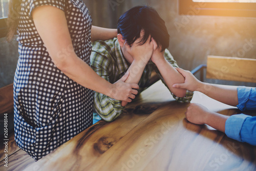 Картината върху платно Two Christian people are praying for young man friends on wood table at church p