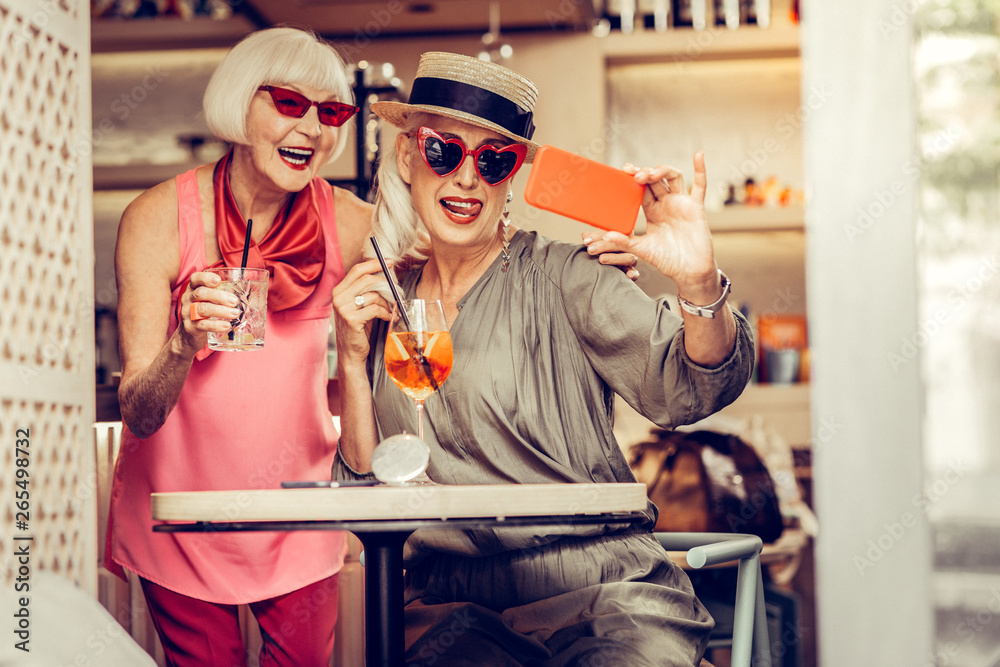 Resolute cheerful senior women wearing bright stylish outfits Resolute cheerful senior women wearing bright stylish outfits