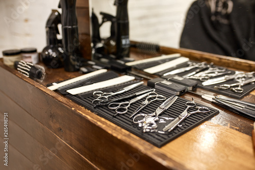 barber tools on wooden shelf and mirror in barbershop