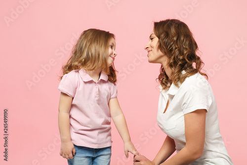 Woman in light clothes have fun with cute child baby girl. Mother, little kid daughter isolated on pastel pink wall background, studio portrait. Mother's Day, love family, parenthood childhood concept