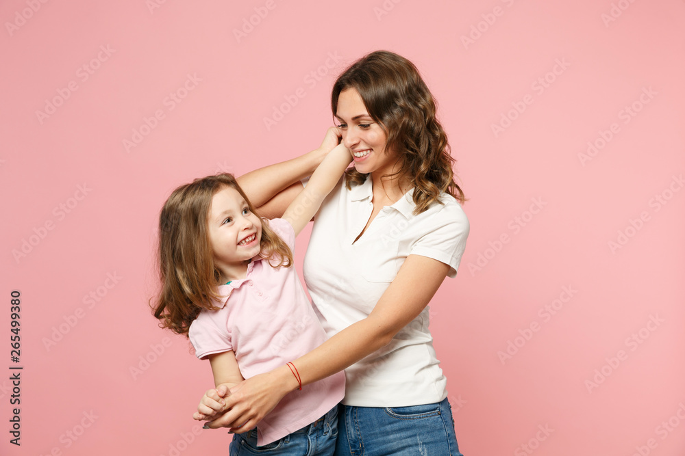 Woman in light clothes have fun with cute child baby girl. Mother, little kid daughter isolated on pastel pink wall background, studio portrait. Mother's Day, love family, parenthood childhood concept