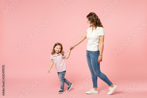 Woman in light clothes have fun with cute child baby girl. Mother, little kid daughter isolated on pastel pink wall background, studio portrait. Mother's Day, love family, parenthood childhood concept