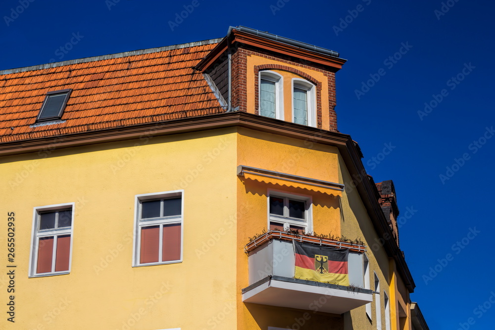Sanierter Altbau mit Deutschlandfahne am Balkon in Berlin, Deutschland