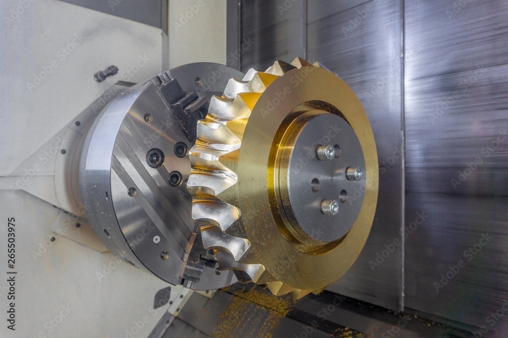 Gear processing on a CNC machine made of bronze, close-up gear cutting production.