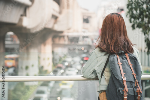 Rear of Woman Traveler with backpack traveling on her summer vacation. Summer Holiday Travel Destination concept.