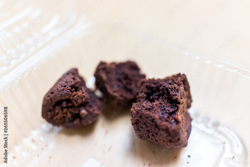 Closeup of baked brownie chocolate cake piece slice or bread in plastic container storebought dessert with crumbles