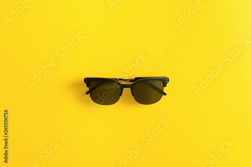 Sunglasses black on yellow background, summer uv protection concept for eyes