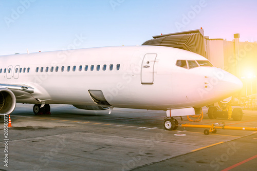 White passenger aircraft parked to a jetway