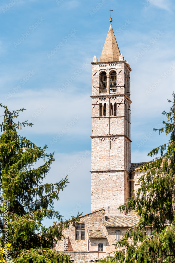 Assisi, Italy town or village city in Umbria with Basilica di Santa Chiara Saint Clare church bell towen during sunny summer day vertical view