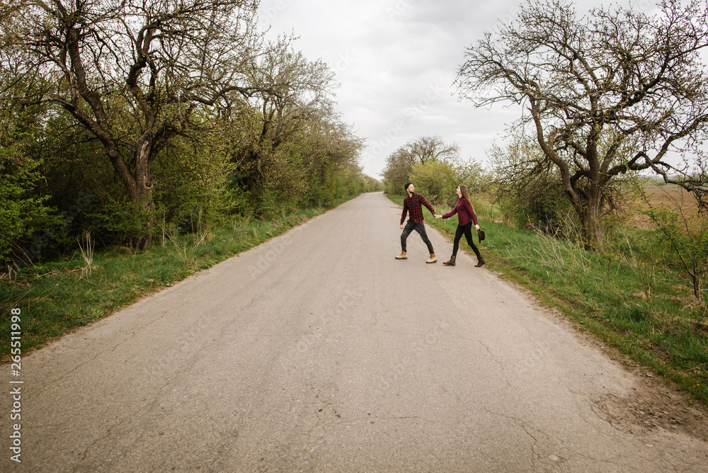 Fototapeta premium A couple walk across the road at the forest