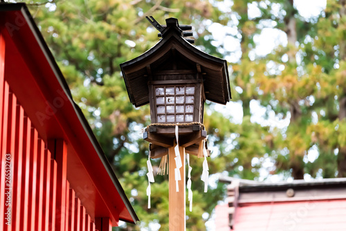 Higashiyama Hakusan Shrine in historical city Takayama, Gifu Prefecture in Japan with closeup of old lantern during day by entrance to temple building © Kristina Blokhin