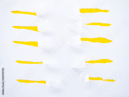 Torn white paper isolated on yellow photo