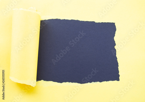 Torn yellow paper isolated on black photo