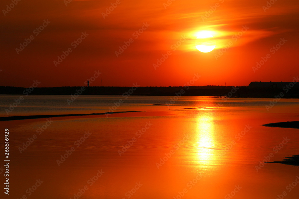 Beautiful orange sunset on the Baltic sea with solar track on the water