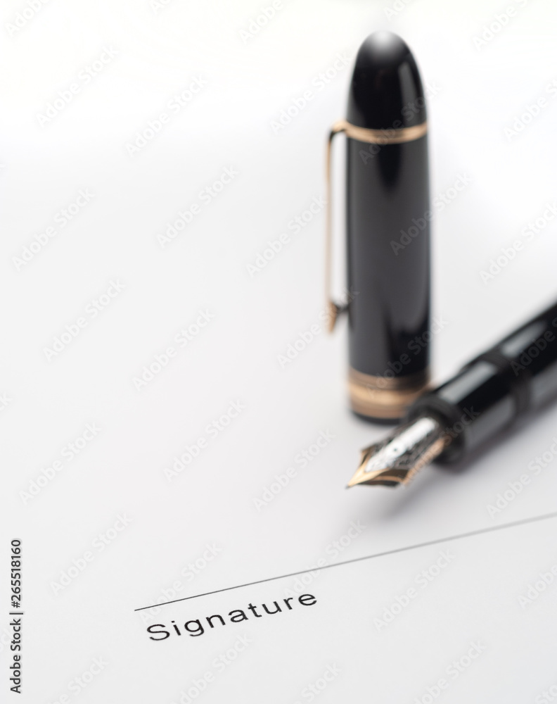 Fototapeta premium Black fountain pen on document pointing to signing area