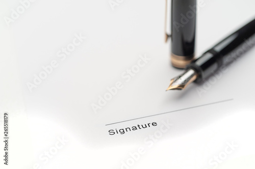 Black fountain pen on document pointing to signing area © Christian Delbert