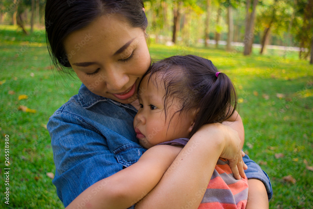 Young mother hugging and soothing a crying little daughter, Asian mother trying to comfort and calm down her crying child Young mother hugging and soothing a crying little daughter, Asian mother trying to comfort and calm down her crying child