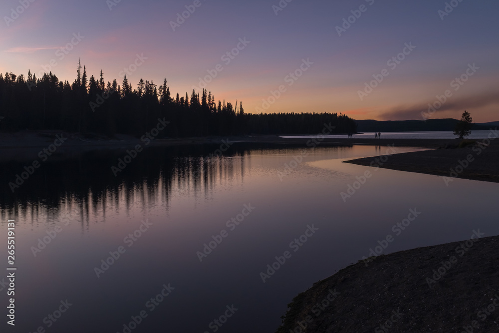 A stunning sunset on a lake in Yellowstone National Park, reflections of colours in the lakes waters A stunning sunset on a lake in Yellowstone National Park, reflections of colours in the lakes waters