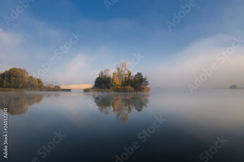 Island on the lake on an autumn morning reflected in the water © uranos1980