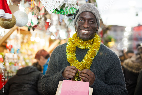 Cheerful man with bags on Christmas market
