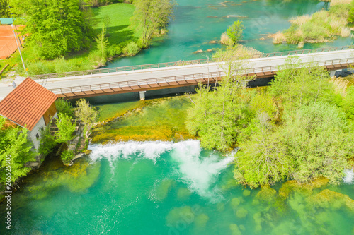 Croatia, green Mreznica river from air, waterfalls, road bridge and old mill in spring, popular tourist destination