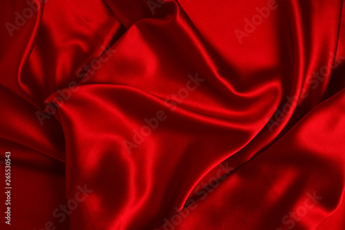 Red silk or satin luxury fabric texture can use as abstract background. Top view.